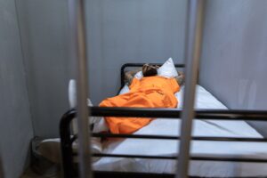 inmate laying in bed